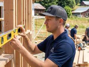 Ryan Knutz checking a wall with a level